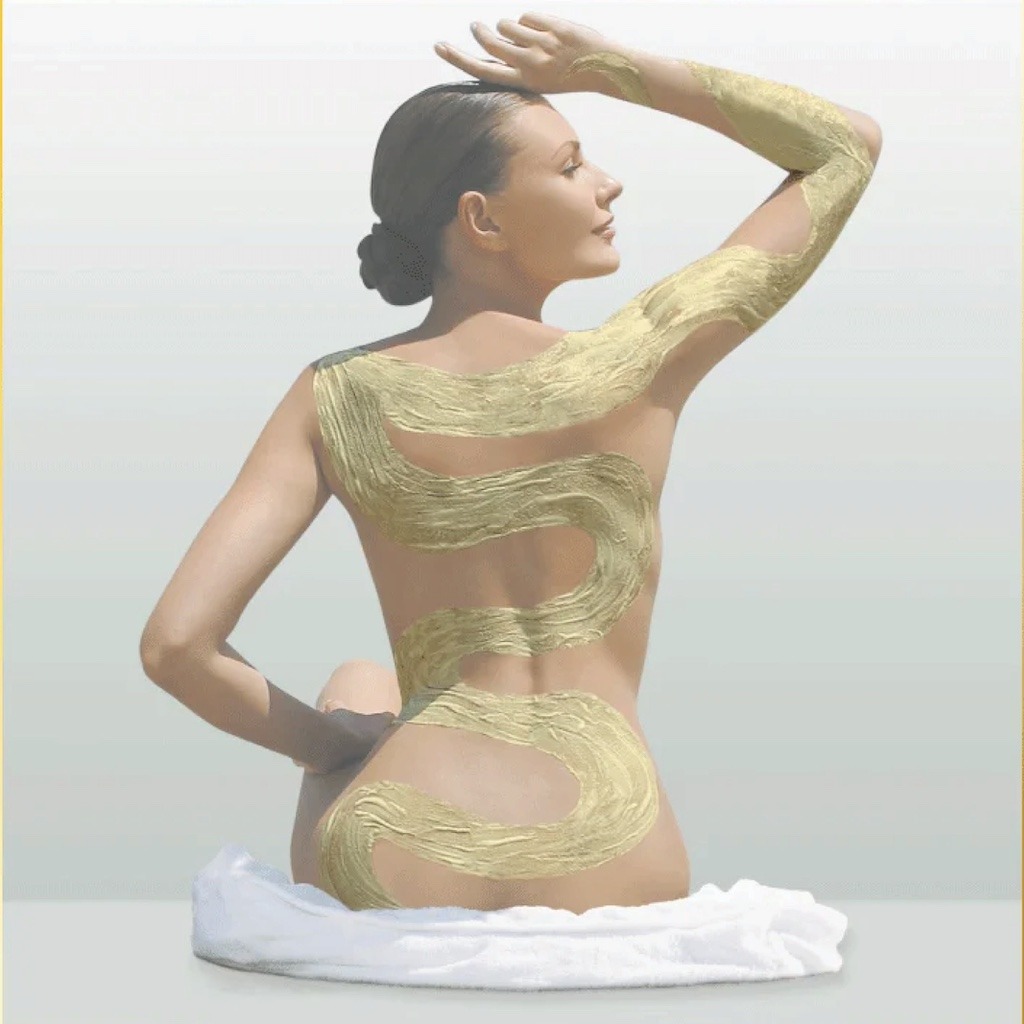 A woman in a spa receiving a luxurious body scrub treatment, with exfoliating scrub applied to her back and arms, highlighting smooth, glowing skin.